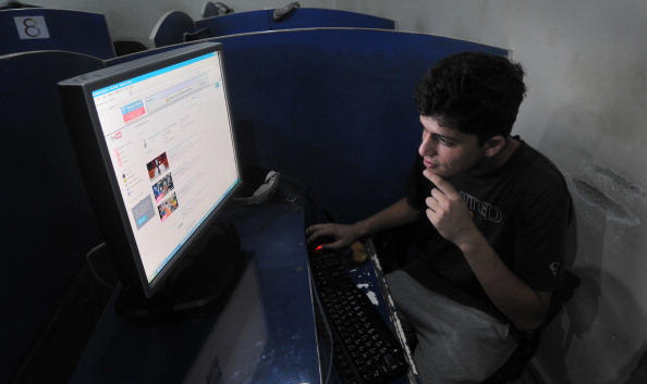 TO GO WITH Pakistan-Unrest-Internet-Islam,FOCUS by Guillaume LAVALLÉE 

This photograph taken on September 9, 2013 shows Pakistani student Abdullah Raheem browsing YouTube at a internet cafe in Lahore. In a dingy Internet cafe, Abdullah gets round the censors with one click and logs onto YouTube, officially banned for a year and at the heart of Pakistan's cyberwar for control of the web. On September 17, 2012 Islamabad blocked access to the popular video sharing website after it aired a trailer for a low-budget American film deemed offensive to Islam and the Prophet Mohammed. Pakistan summoned the most senior US diplomat in the country to protest against the "Innocence of Muslims", demanding that the film be removed and action taken against its producers. A year later, the film is barely mentioned but YouTube, whose parent company is US multinational Google Inc, is still banned in Pakistan, as it is in China and Iran. AFP PHOTO / ARIF ALI        (Photo credit should read Arif Ali/AFP/Getty Images)