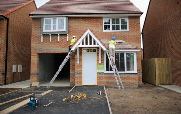 MIDDLEWICH, ENGLAND - MAY 20:  Construction workers build new houses on a housing development on May 20, 2014 in Middlewich, England. Official figures have shown that house prices have risen by 8% in the year ending in March. There have been calls by some experts for the UK Help to Buy scheme to be scaled down as it boosts the property market.  (Photo by Christopher Furlong/Getty Images)