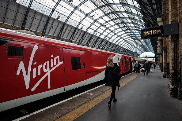 LONDON, ENGLAND - MAY 16: Passengers board a Virgin Trains East Coast train at Kings Cross Station on May 16, 2018 in London, England. East Coast trains are to be brought back under state control after Stagecoach and Virgin suffer a revenue shortfall on the £3.3bn contract to run the franchise. (Photo by Jack Taylor/Getty Images)
