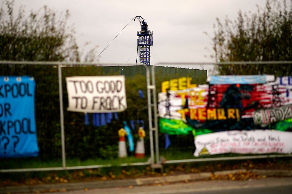 BLACKPOOL, ENGLAND - OCTOBER 25: The derrick is seen behind anti-fracking banners at the Preston New Road drill site where energy firm Cuadrilla Resources have recommenced fracking operations to extract shale gas, on October 25, 2018 in Blackpool, England. Operations at the shale gas extraction site were recently paused by Cuadrilla as a precaution after an earth tremor measuring 0.4 was detected by sensors. (Photo by Christopher Furlong/Getty Images)