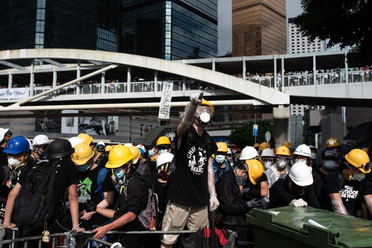Hong Kong protesters chant slogans on Harcourt Road outside the government headquarters after the annual flag raising ceremony to mark the 22nd anniversary of the city's handover from Britain to China