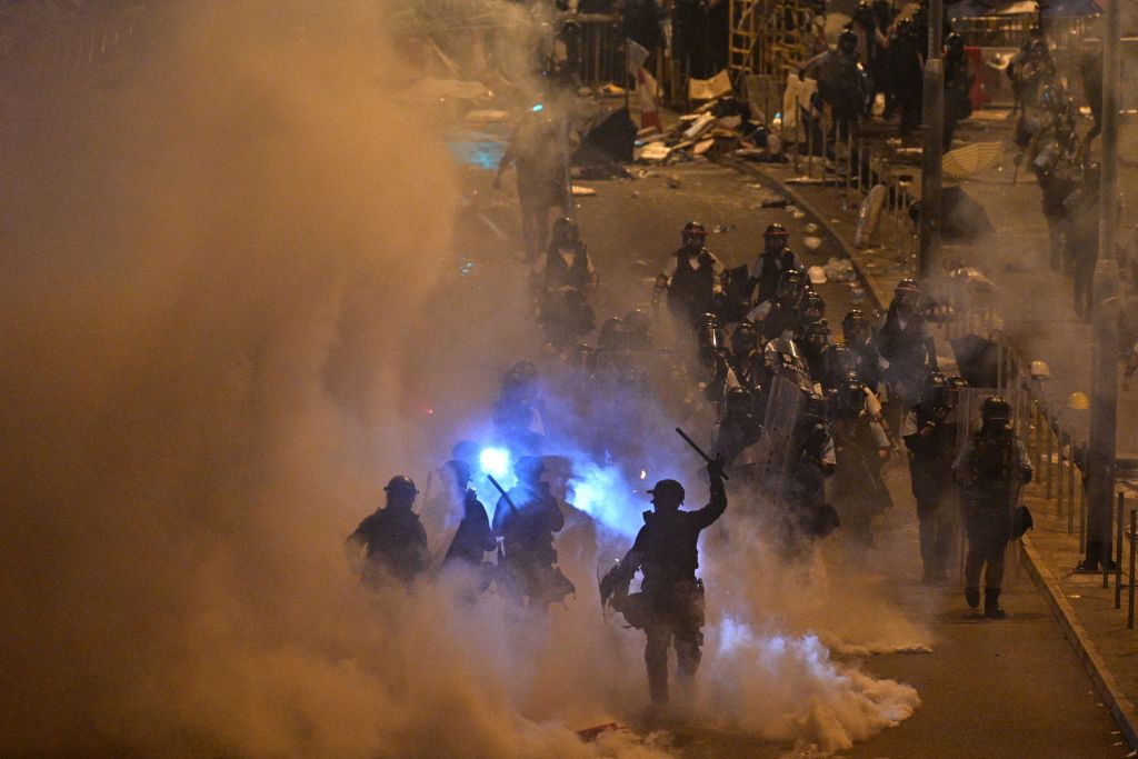 TOPSHOT - Police fire tear gas at protesters near the government headquarters in Hong Kong on July 2, 2019. - Riot police fired tear gas as they attempted to dislodge anti-government protesters in the early hours of the morning of July 2 in chaotic scenes in the heart of Hong Kong. (Photo by Anthony WALLACE / AFP)        (Photo credit should read ANTHONY WALLACE/AFP/Getty Images)