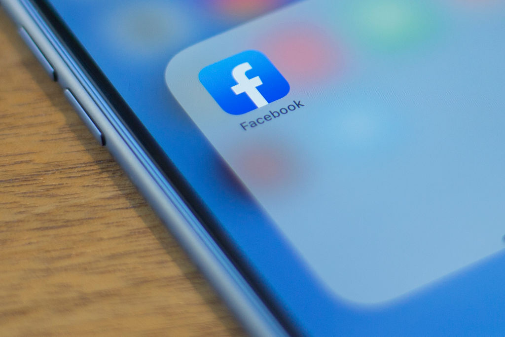 The Facebook logo is seen on a phone in this photo illustration in Washington, DC, on July 10, 2019. (Photo by Alastair Pike / AFP)        (Photo credit should read ALASTAIR PIKE/AFP/Getty Images)