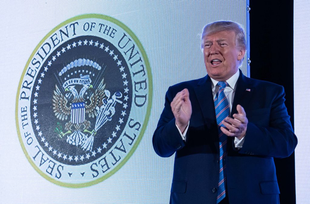 U.S. President Donald Trump stands next to a surreptitiously altered presidential seal as he arrives to address the Turning Point USAs Teen Student Action Summit 2019 in Washington, DC, on July 23, 2019. (Photo by NICHOLAS KAMM / AFP)        (Photo credit should read NICHOLAS KAMM/AFP/Getty Images)