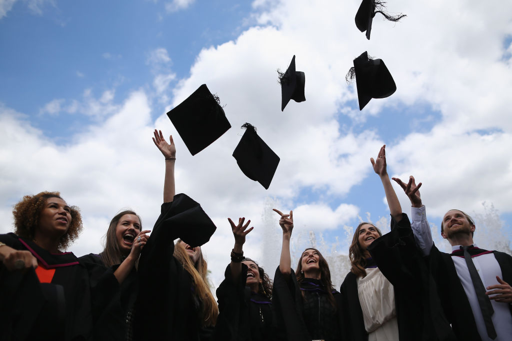 LONDON, ENGLAND - JULY 15:  Students throw their caps in the air ahead of their graduation ceremony at the Royal Festival Hall on July 15, 2014 in London, England. Students of the London College of Fashion, Management and Science and Media and Communication attended their graduation ceremony at the Royal Festival Hall today.  (Photo by Dan Kitwood/Getty Images)