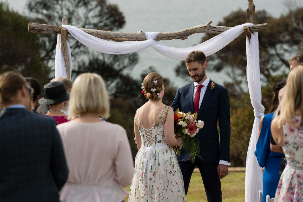 TATHRA , NEW SOUTH WALES - MARCH 24:  Sam Dawson and David Hutchinson tie the knot on Tathra headland on March 24, 2018 in Tathra, Australia. 6 months in the planning, the couple only decided to go ahead with the wedding late in the week after the devasting bushfires hit the town.  The bushfire, which started on 18 March, destroyed 65 houses, 35 caravans and cabins, and damaged 48 houses. Preliminary investigations have found that power lines were the likely cause of the fire, raising questions about the maintenance of  power infrastructure by Essential Energy, which is owned by the NSW government.  (Photo by Brook Mitchell/Getty Images)