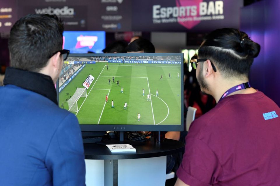 Visitors plays on EA Vancouver video game developer's football simulation video game FIFA 19 at the eSports Bar trade fair in Cannes, southern France on February 13, 2019. - After several years of development under radars, eSports is attracting more and more major brands that are betting on this sector in "structuring phase" to communicate with a different but committed target, according to Stephane Gambetta, director of activities and strategy at Reed Midem, the organizer of the eSports Bar trade fair in Cannes. (Photo by YANN COATSALIOU / AFP)        (Photo credit should read YANN COATSALIOU/AFP/Getty Images)