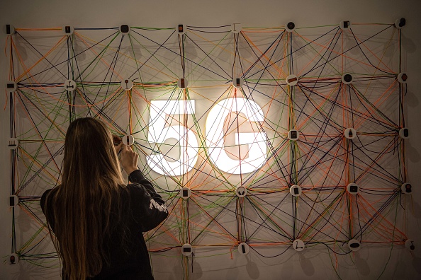 BARCELONA, SPAIN - FEBRUARY 26:  A staff member works next to a 5G logo at the Xiaomi booth on day 2 of the GSMA Mobile World Congress 2019 on February 26, 2019 in Barcelona, Spain. The annual Mobile World Congress hosts some of the world's largest communications companies, with many unveiling their latest phones and wearables gadgets like foldable screens and the introduction of the 5G wireless networks. (Photo by David Ramos/Getty Images)
