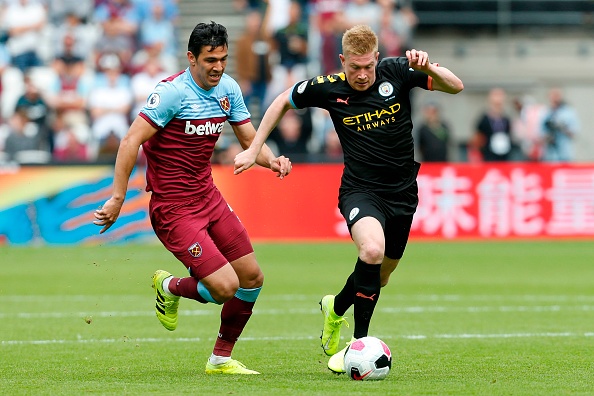 West Ham United's Paraguayan defender Fabián Balbuena (L) chases Manchester City's Belgian midfielder Kevin De Bruyne (R) during the English Premier League football match between West Ham United and Manchester City at The London Stadium, in east London on August 10, 2019. (Photo by Ian KINGTON / AFP) / RESTRICTED TO EDITORIAL USE. No use with unauthorized audio, video, data, fixture lists, club/league logos or 'live' services. Online in-match use limited to 120 images. An additional 40 images may be used in extra time. No video emulation. Social media in-match use limited to 120 images. An additional 40 images may be used in extra time. No use in betting publications, games or single club/league/player publications. /         (Photo credit should read IAN KINGTON/AFP/Getty Images)