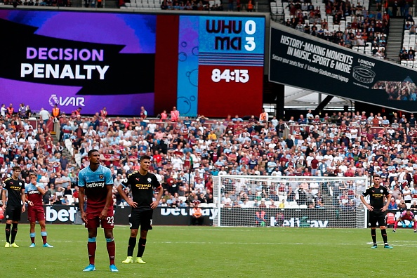 The big screen displays the VAR decision ruling that a Manchester City penalty, that on the first attempt was saved, must be retaken during the English Premier League football match between West Ham United and Manchester City at The London Stadium, in east London on August 10, 2019. (Photo by Ian KINGTON / AFP) / RESTRICTED TO EDITORIAL USE. No use with unauthorized audio, video, data, fixture lists, club/league logos or 'live' services. Online in-match use limited to 120 images. An additional 40 images may be used in extra time. No video emulation. Social media in-match use limited to 120 images. An additional 40 images may be used in extra time. No use in betting publications, games or single club/league/player publications. / (Photo credit should read IAN KINGTON/AFP/Getty Images)