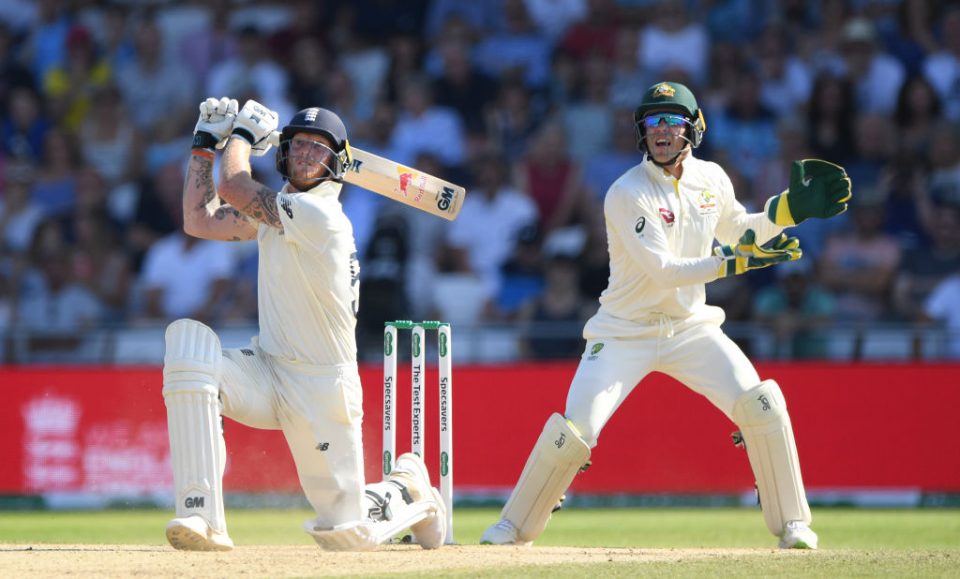 LEEDS, ENGLAND - AUGUST 25: England batsman Ben Stokes hits a ball for 6 runs watched by Tim Paine during day four of the 3rd Ashes Test Match between England and Australia at Headingley on August 25, 2019 in Leeds, England. (Photo by Stu Forster/Getty Images)