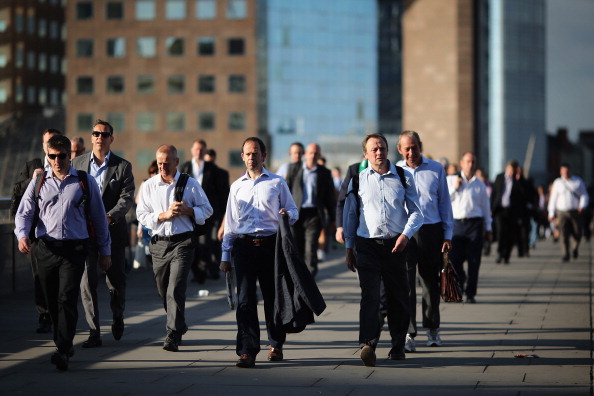 LONDON, ENGLAND - JULY 17: City Workers walk along London Bridge in the early morning sunshine on July 17, 2014 in London, England. The Met Office has issued a heatwave alert as temperatures throughout England and Wales are predicted to reach their highest level of the year this weekend. (Photo by Dan Kitwood/Getty Images)