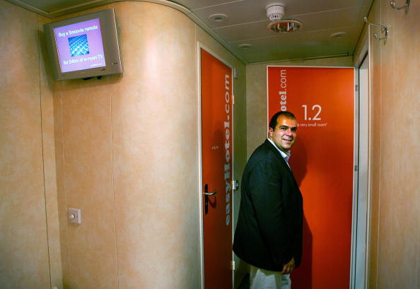 London, UNITED KINGDOM: Entrepreneur Stelios Haji-Ioannou poses inside one of "the very small rooms" in his latest venture easyHotel in London 01 August 2005. EasyHotel represents the easyGroup entry into the budget hotel sector and will be found in the centre of international cities, targeting short-stay customers. The no-frills rooms in the west London hotel cost approzimately GBP20 (E30) but the price is on the basis of the earlier you book, the less you pay. AFP PHOTO ADRIAN DENNIS (Photo credit should read ADRIAN DENNIS/AFP/Getty Images)