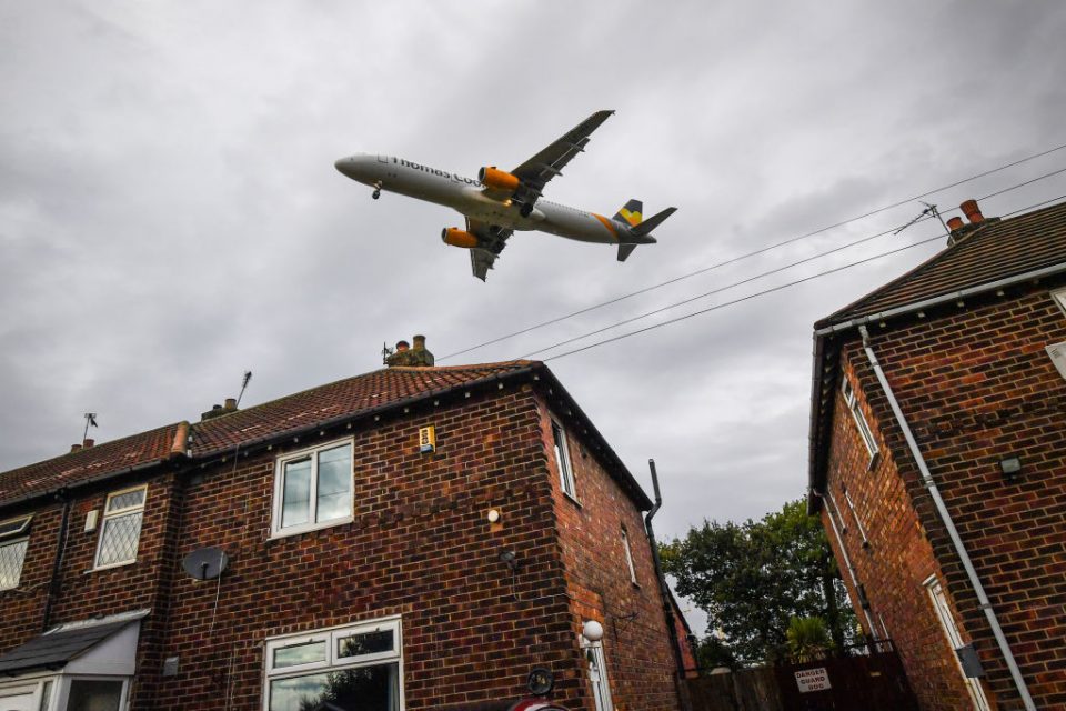 A Thomas Cook plane can be seen above a row of houses