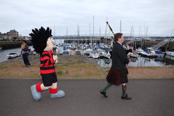 DUNDEE, SCOTLAND - JUNE 27:  (EDITORIAL USE ONLY, NO SALES)  In this handout image provided by Glasgow 2014 Ltd, Beano character Dennis the Menace carries the Glasgow 2014 Queen's Baton through Broughty Ferry in Dundee during the Glasgow 2014 Queen's Baton relay on June 27, 2014 in Dundee, Scotland.  Scotalnd is nation 70 of 70 nations and territories the Queen's Baton will visit. (Photo by Chris Radburn/Glasgow 2014 Ltd via Getty Images)