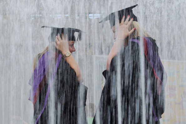LONDON, ENGLAND - JULY 15:  Students stand in a fountain ahead of their graduation ceremony at the Royal Festival Hall on July 15, 2014 in London, England. Students of the London College of Fashion, Management and Science and Media and Communication attended their graduation ceremony at the Royal Festival Hall today.  (Photo by Dan Kitwood/Getty Images)