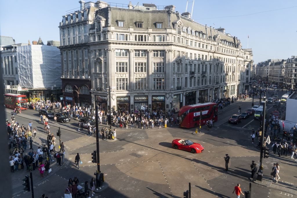 Pedestrians and vechiles cross the junction after police cleared climate change activists blocking the road at Oxford Circus in London on April 20, 2019, on the sixth day of an environmental protest by the Extinction Rebellion group. - Climate change activists continued their demonstration into a sixth day in London with protest camps at iconic locations despite over 700 arrests. (Photo by Niklas HALLE'N / AFP)        (Photo credit should read NIKLAS HALLE'N/AFP/Getty Images)