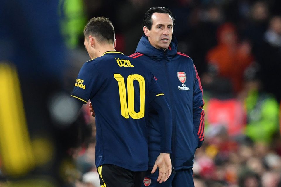 Arsenal's German midfielder Mesut Ozil (L) passes Arsenal's Spanish head coach Unai Emery as he leaves the pitch after being substituted off during the English League Cup fourth round football match between Liverpool and Arsenal at Anfield in Liverpool, north west England on October 30, 2019. (Photo by Paul ELLIS / AFP) / RESTRICTED TO EDITORIAL USE. No use with unauthorized audio, video, data, fixture lists, club/league logos or 'live' services. Online in-match use limited to 75 images, no video emulation. No use in betting, games or single club/league/player publications. /  (Photo by PAUL ELLIS/AFP via Getty Images)