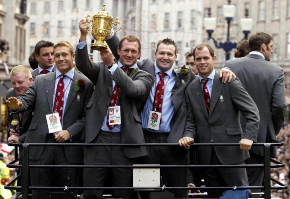 LONDON, UNITED KINGDOM:  England's (front left-right) Jonny Wilkinson, Richard Hill, Mark Regan and Kyran Bracken ride the open-top bus with the Webb Ellis Cup during the Victory Parade in London, 08 December, 2003. Later the England Rugby World Cup winners were travelling to receptions at Buckingham Palace and Downing Street.   AFP PHOTO/DAVID DAVIES/WPA POOL  (Photo credit should read DAVID DAVIES/AFP/Getty Images)