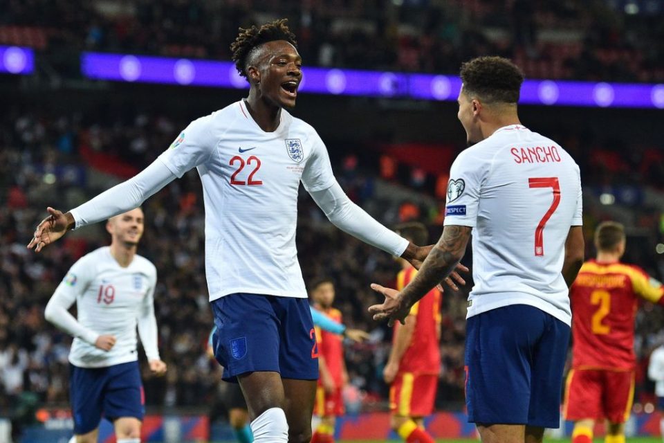 England's striker Tammy Abraham (L) celebrates with England's midfielder Jadon Sancho (R) after scoring their seventh goal during the UEFA Euro 2020 qualifying first round Group A football match between England and Montenegro at Wembley Stadium in London on November 14, 2019. - England won the game 7-0. (Photo by Glyn KIRK / AFP) / NOT FOR MARKETING OR ADVERTISING USE / RESTRICTED TO EDITORIAL USE (Photo by GLYN KIRK/AFP via Getty Images)