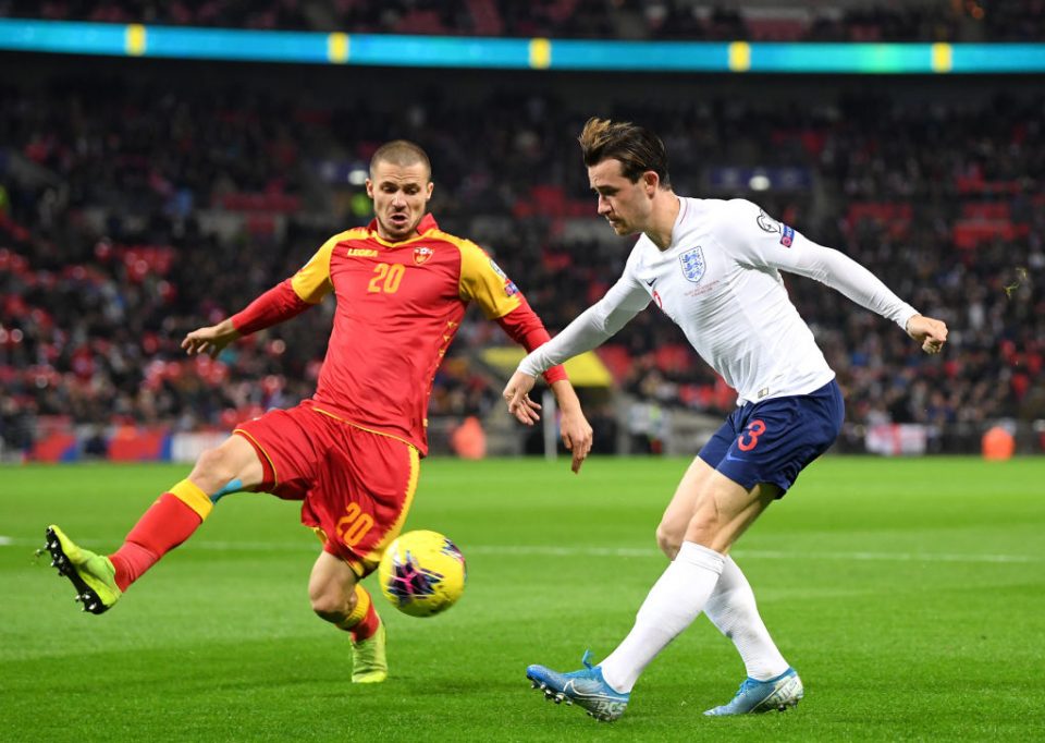 LONDON, ENGLAND - NOVEMBER 14: Ben Chilwell of England crosses under pressure from Aleksandar Sofranac of Montenegro during the UEFA Euro 2020 qualifier between England and Montenegro at Wembley Stadium on November 14, 2019 in London, England. (Photo by Michael Regan/Getty Images)