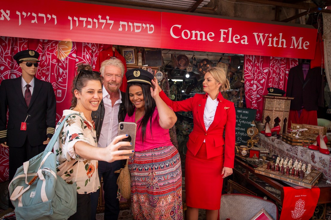 To celebrate Virgin Atlantic’s inaugural flight to Tel Aviv, Virgin founder and international Businessman Sir Richard Branson operates a pop-up travel agency in the middle of the city’s famous Jaffa Market
The Secret Travel Agent initiative celebrates  Tel Aviv’s social practice of haggling as its residents negotiate with this business giant for flights to London
Sir Richard also threw in additional items such as flight bags and Virgin Atlantic merchandise to tempt his customers to make a deal, mirroring Virgin Atlantic’s ethos of maximising customer experience with added extras
The twist is Sir Richard will be giving away a limited number of flights to London for those who are the fiercest negotiators.