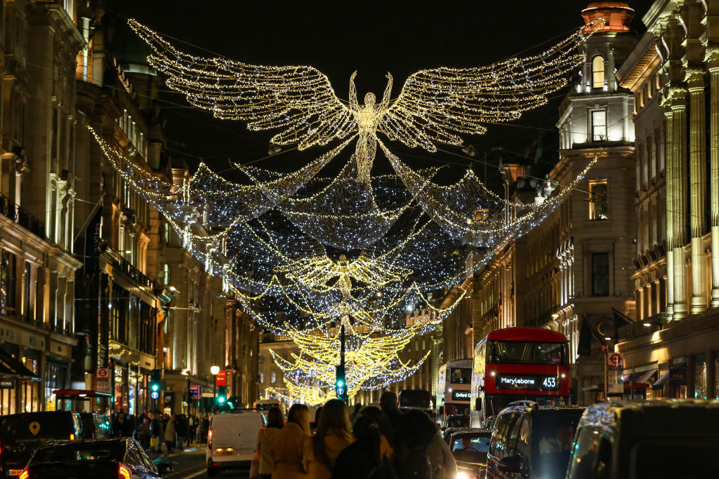 Shoppers walk under Christmas lights hanging on Regent Street