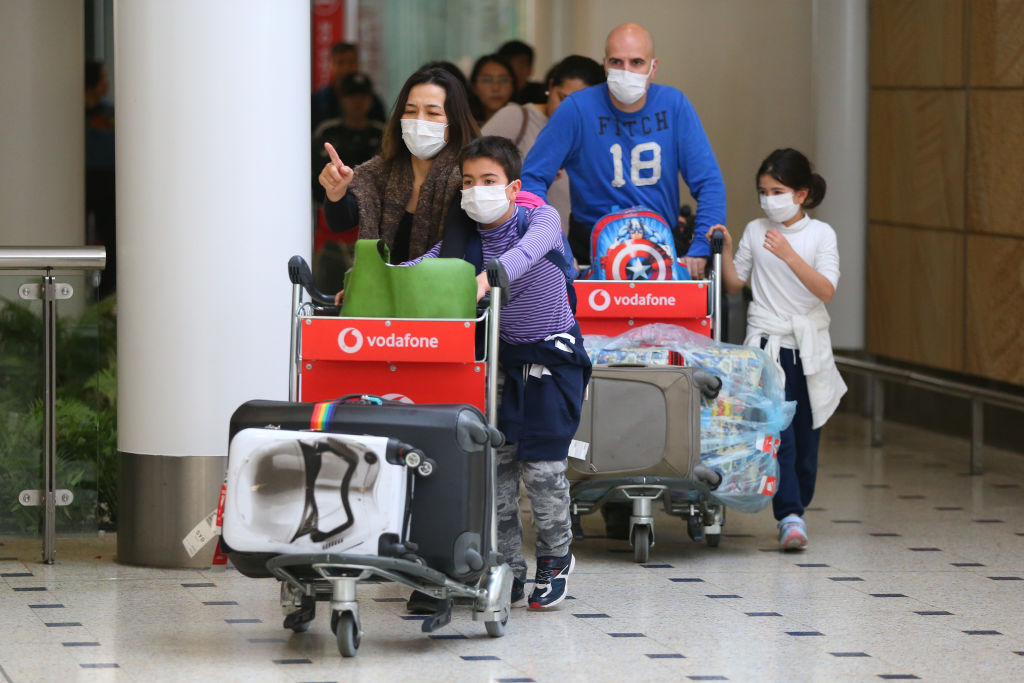 Australian citizens arrive from Wuhan wearing masks in a bid to slow the spread of the coronavirus