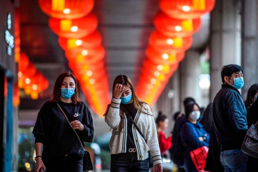 Pedestrians wear face masks as they walk outside the New Orient Landmark hotel in Macau amid the coronavirus outbreak