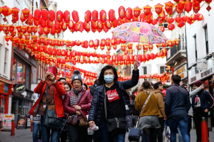 Woman wears a face mask in Chinatown as two new UK coronavirus cases confirmed