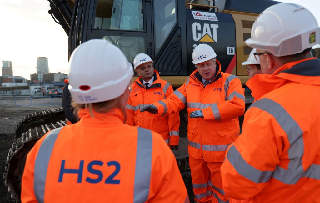 Britain's Prime Minister Boris Johnson (C) stands with Britain's Chancellor of the Exchequer Sajid Javid (2L) as they talk with apprentices during his visit to Curzon Street railway station in Birmingham, central England on February 11, 2020, where the High Speed 2 (HS2) rail project is under construction. - Britain said Tuesday it will begin full construction work on its new high-speed railway line in April following years of delays, after Prime Minister Boris Johnson backed the project despite soaring costs. Johnson said the entire HS2 line linking London to central and northern England would go ahead, rejecting criticism of its ballooning price tag and impact on the environment. (Photo by EDDIE KEOGH / POOL / AFP) (Photo by EDDIE KEOGH/POOL/AFP via Getty Images)