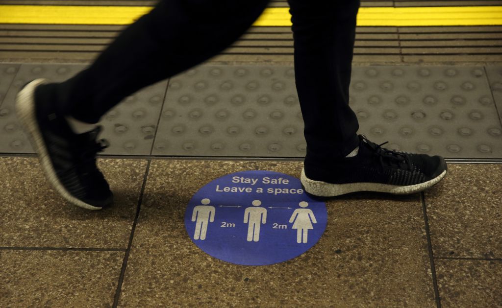 A sign on the platform at Embankment Underground station tells commuters that they need to observe a two-metre gap as they travel. This will now change to a one metre gap.