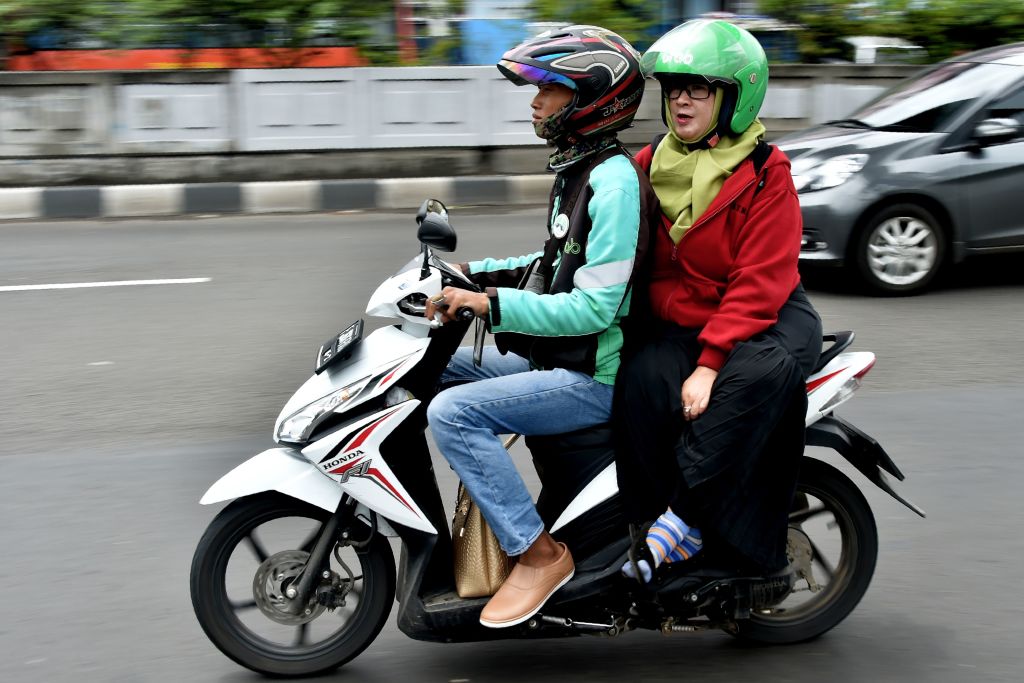 A GrabBike rider transports a passenger in Jakarta in 2017