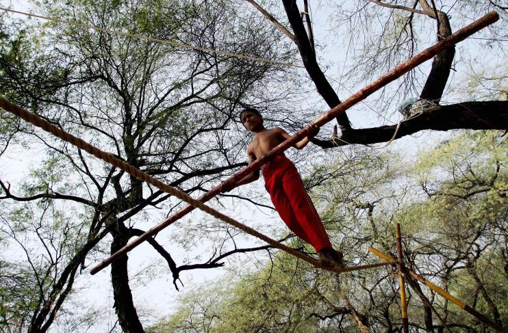 A young Indian trapeze artist walks the...