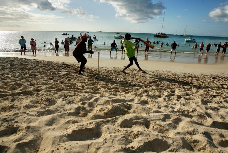 A batsman plays a shot during a beach cr...