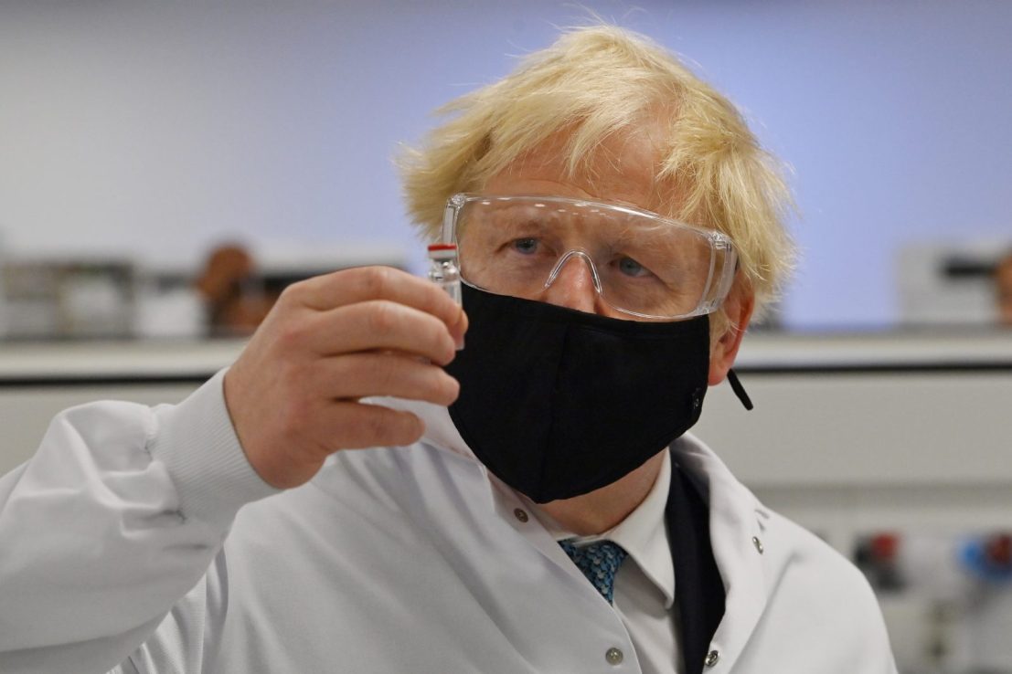 Prime Minister Boris Johnson poses for a photograph with a vial of the AstraZeneca/Oxford University COVID-19 candidate vaccine