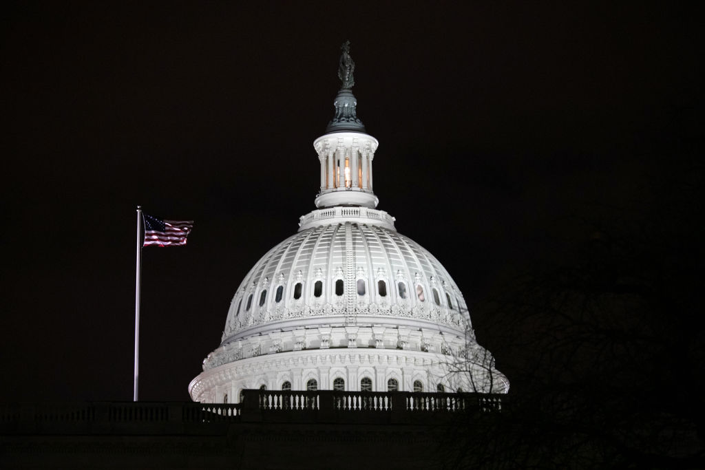 A US flag flies in front of the US Capitol, which yesterday was broken into by a pro-Trump mob. (Photo by John Moore/Getty Images)