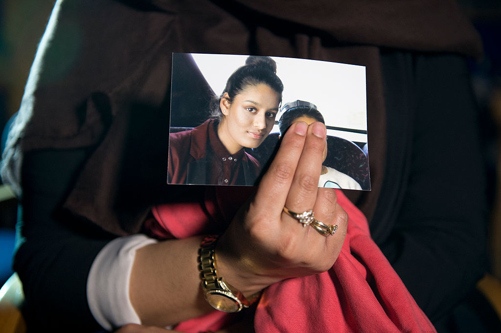 Renu Begum, eldest sister of Shamima Begum, 15, holds her sister's photo (Photo by Laura Lean - WPA Pool/Getty Images)
