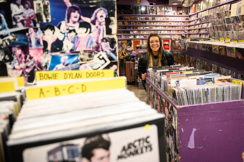 A woman moves a display of vinyl records outside the store as it re-opens in Camden Market, following the change in lockdown restrictions on April 12, 2021 in London, United Kingdom. (Photo by Leon Neal/Getty Images)