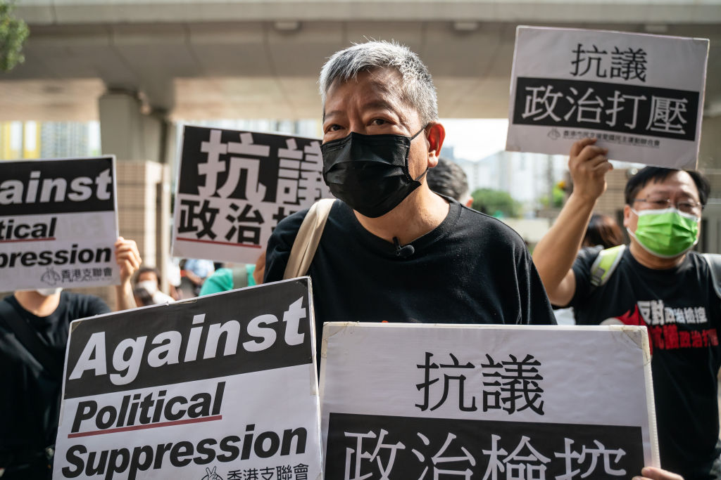 HONG KONG, CHINA - APRIL 01: Pro-democracy activist and former lawmaker Lee Cheuk-yan hold placards outside the West Kowloon Magistrates Courts ahead of a hearing  on April 1, 2021 in Hong Kong, China. Seven prominent democratic figures, including Apple Daily founder Jimmy Lai, former lawmaker and barrister Martin Lee and Margaret Ng were convicted of unauthorized assembly in relation to a peaceful protest in 2019. (Photo by Anthony Kwan/Getty Images)