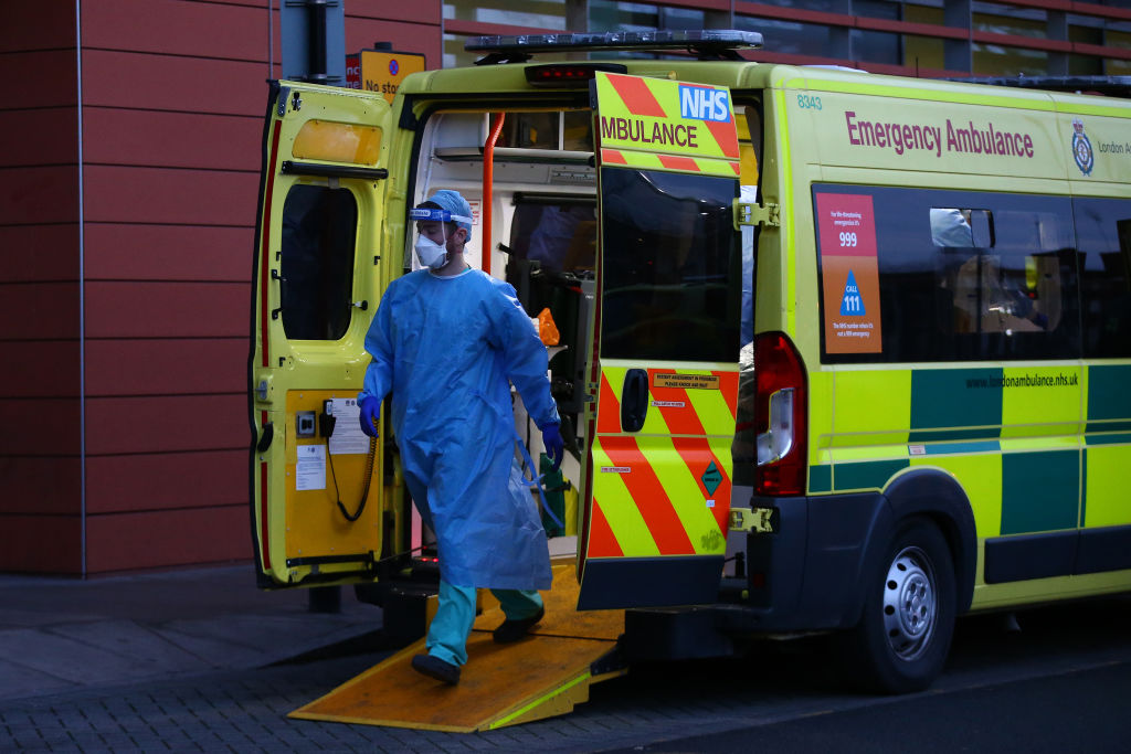 A medic wearing PPE prepares to remove a patient from an ambulance at the Royal London Hospital. (Photo by Hollie Adams/Getty Images)