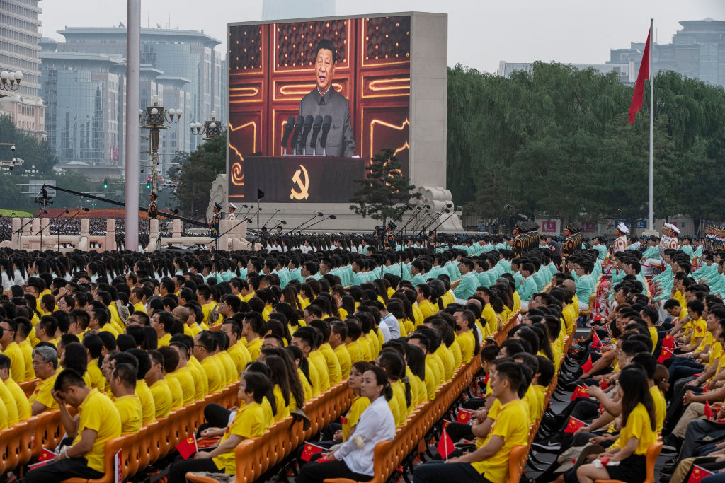 Chinese President Xi Jinping is seen on a screen as the crowd listens during his speech at a ceremony marking the 100th anniversary of the Communist Party at Tiananmen Square. (Photo by Kevin Frayer/Getty Images)