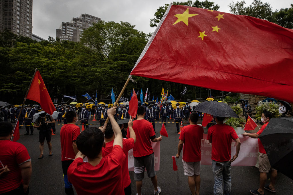 Chinese Communist Party supporters wave flags and shout at Shinjuku Central Park on July 01, 2021 in Tokyo, Japan. (Photo by Takashi Aoyama/Getty Images)