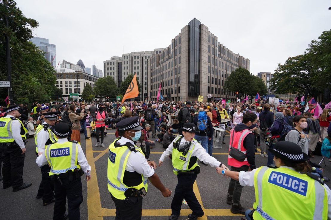 Police and members of Extinction Rebellion at Tower Hill during their march in central London in August of last year. The government is proposing new rules for public protests. 