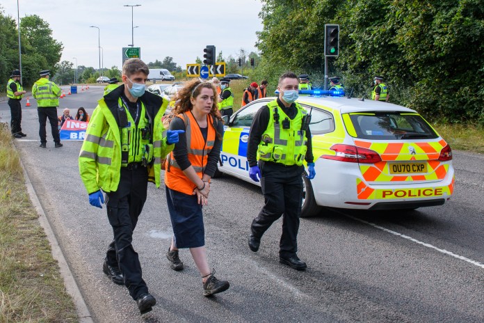 An Insulate Britain protestor is taken away from a protest site on the M25 by police .