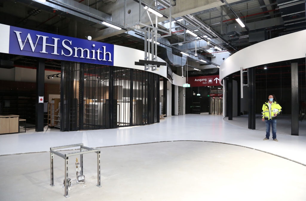 An employee stands near a closed WH Smith store in Berlin Airport