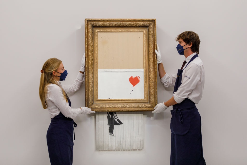 The painting of a young girl holding a red heart-shaped balloon by the elusive British street artist became one of the most famous artworks ever when it attempted to shred itself the moment after it sold at auction in 2018. (Photo by Tristan Fewings/Getty Images for Sotheby's)