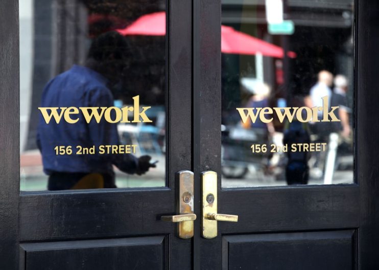 SAN FRANCISCO, CALIFORNIA - OCTOBER 07: A pedestrian walks by a WeWork office on October 07, 2019 in San Francisco, California. Days after withdrawing its registration for an initial public offering, WeWork also warned employees that the company could be set to lay off nearly 2,000 people, about 16 percent of its workforce. (Photo by Justin Sullivan/Getty Images)