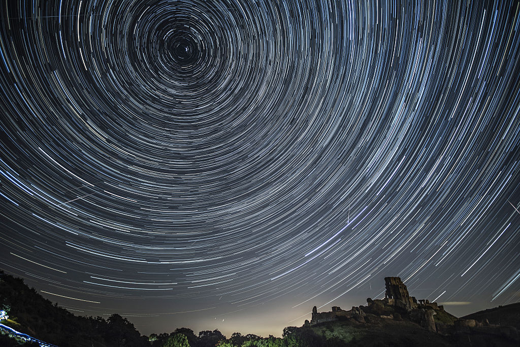 CORFE CASTLE, UNITED KINGDOM - AUGUST 12:  (EDITORS NOTE: THIS IS A COMPOSITE IMAGE) Satellites, planes and comets transit across the night sky under stars that appear to rotate above Corfe Castle on August 12, 2016 in Corfe Castle, United Kingdom. The Perseids meteor shower occurs every year when the Earth passes through the cloud of debris left by Comet Swift-Tuttle, and appear to radiate from the constellation Perseus in the north eastern sky.  (Photo by Dan Kitwood/Getty Images)