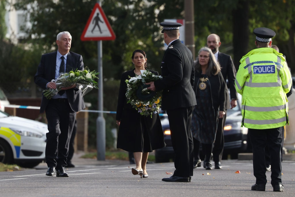 LEIGH-ON-SEA, ENGLAND - OCTOBER 16: (L-R) Sir Lindsay Hoyle, Speaker of the House of Commons, and Priti Patel, Home Secretary, lay flowers at Belfairs Methodist Church on October 16, 2021 in Leigh-on-Sea, United Kingdom. Counter-terrorism officers are investigating the murder of Sir David Amess, the Conservative MP for Southend West, who was stabbed to death during his constituency surgery yesterday around midday.  A man in his twenties was arrested at the scene.  (Photo by Hollie Adams/Getty Images)